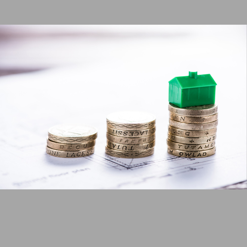 image of a monopoly house on stakcs of coins, representative of the investment properties service provided by Canadian Mortgage Broker Michelle Campbell